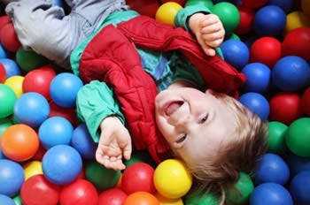 Young child playing in children's ball pit. Young child playing in children's ball pit.