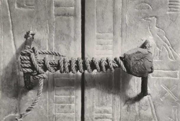 Harry Burton's photograph records the intact necropolis seal and cord fastening on the third (of four) great gilded shrines surrounding Tutankhamun's sarcophagus in the Burial chamber. The unbroken seal confirmed that the King's body remained undisturbed, despite the tomb having been broken into and robbed several times in antiquity (Public Domain).