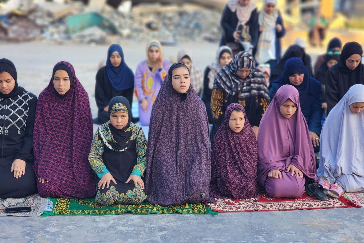 Displaced Palestinians gather at the courtyard of the Martyrs' School to perform Eid al-Fitr prayers.