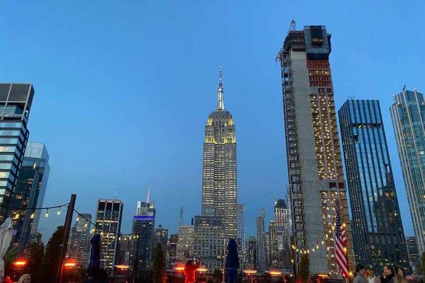 A view of the NYC skyline at dusk from a rooftop bar