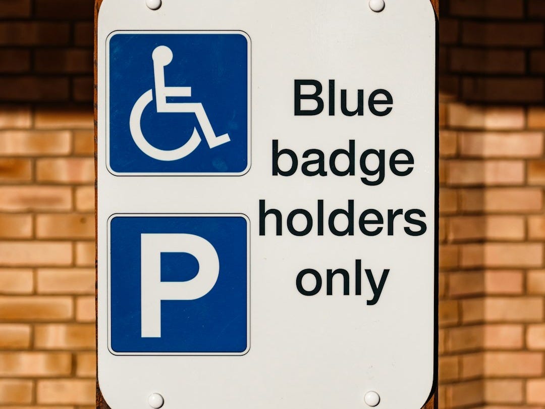 a blue and white sign that says blue badge holders only