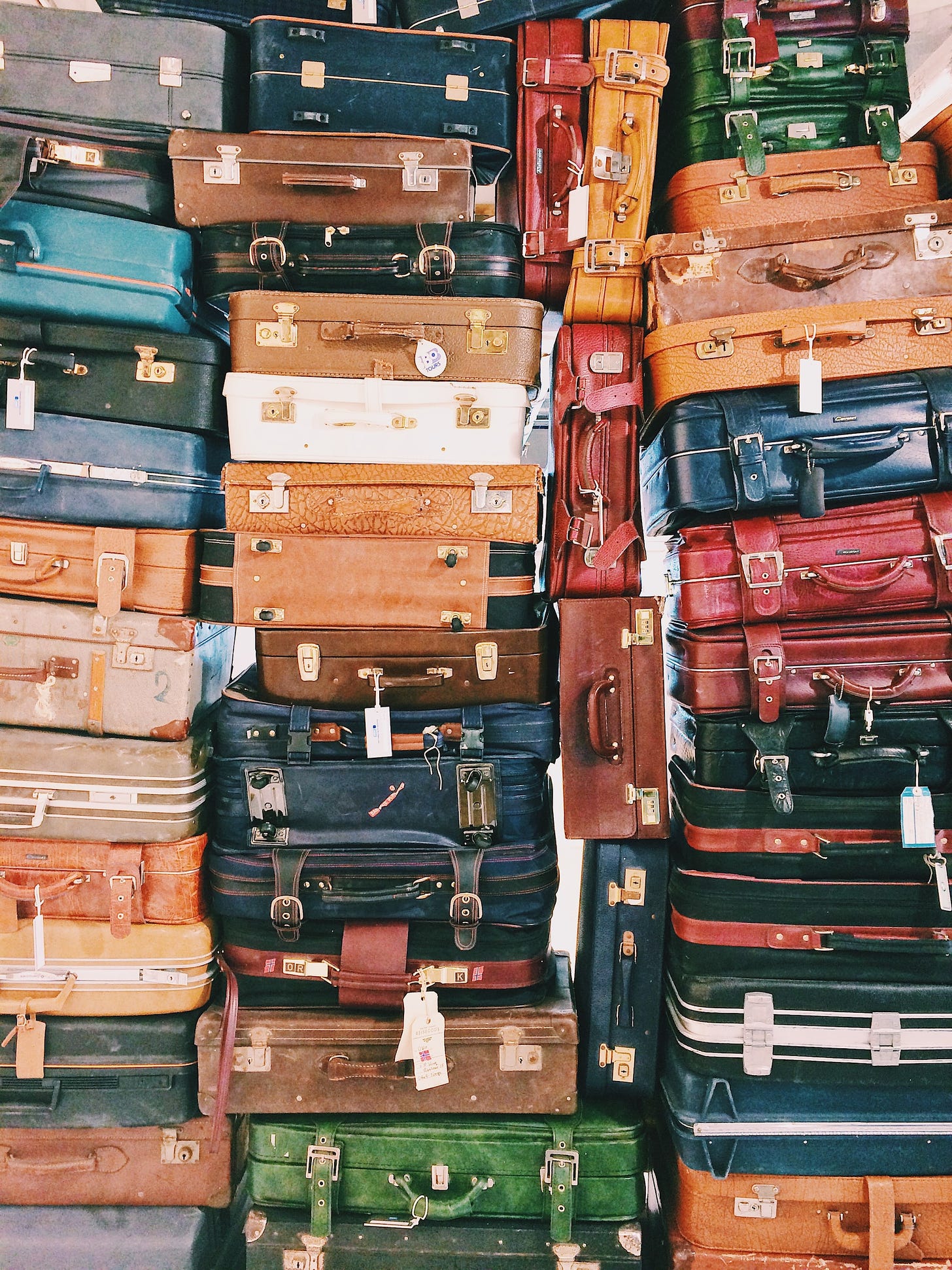 A stack of suitcases piled high, creating a tower of travel essentials