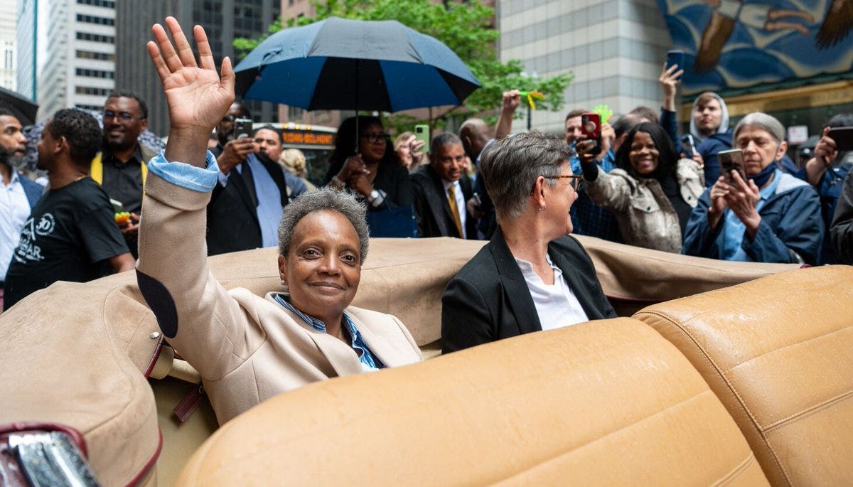 Mayor Lori Lightfoot waves goodby to supporters from the back of a 1940s Cadillac convertible on Friday.