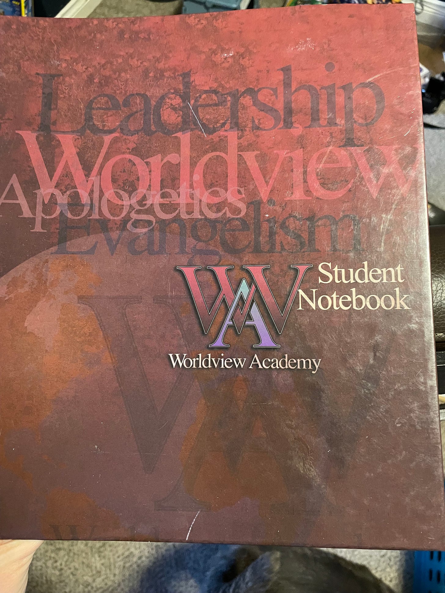 red distressed workbook cover that says leadership worldview apologetics evangeliclaism wordlveiw acadamy student notebook