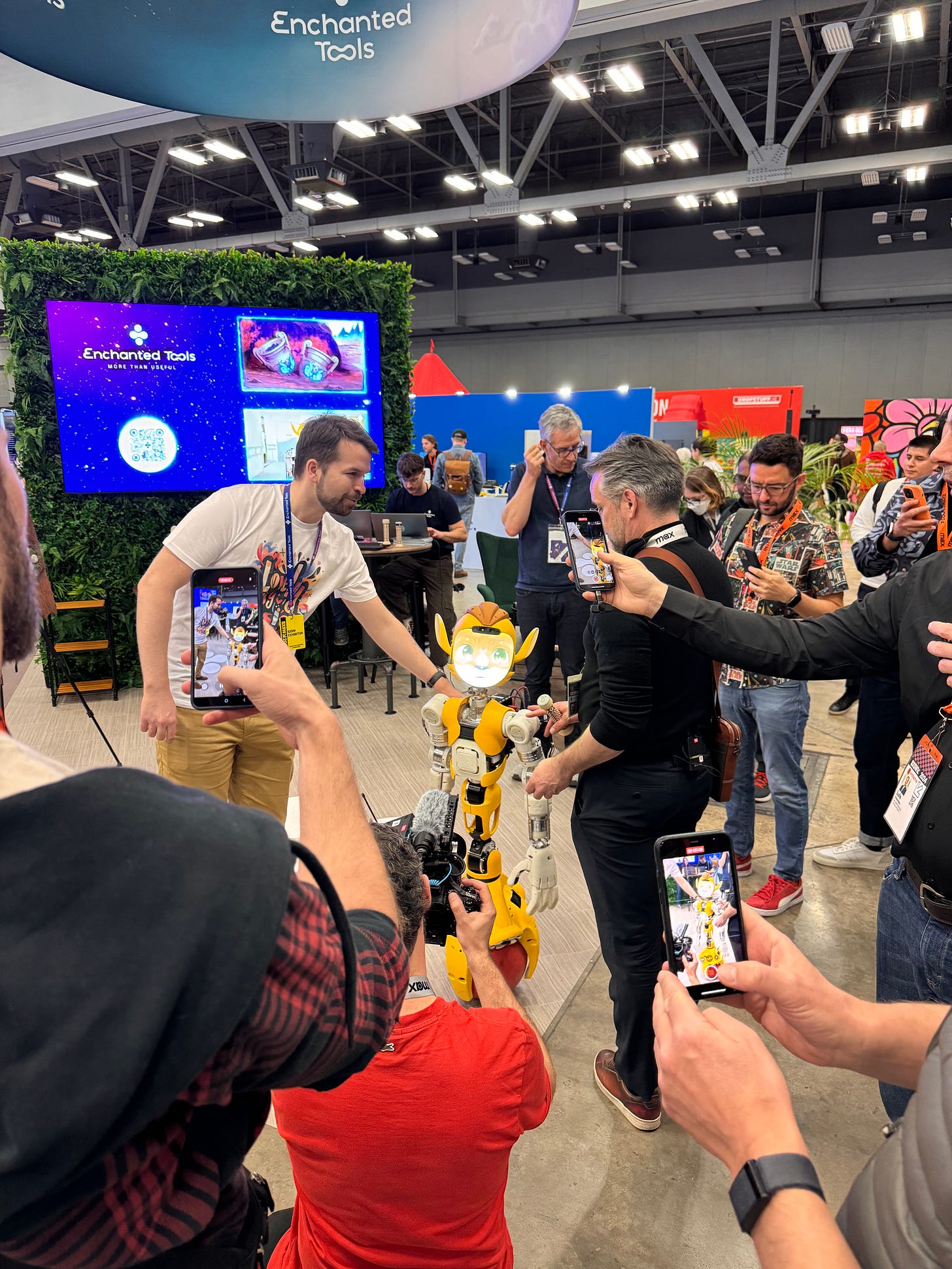 In the exhibition hall, a crowd of SXSW attendees gather around an upright one-wheel robot with a face like a lion. Everyone has their phones out and is snapping photos/videos. The company logo "Enchanted Tools" is in the background.