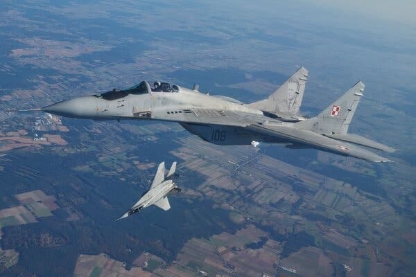 Two military jets fly near each other in a drill over Poland.