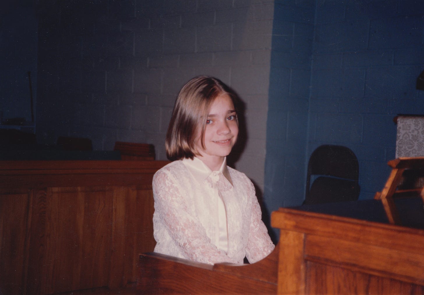 A photo of me fake smiling at the camera during a piano recital in grade school.
