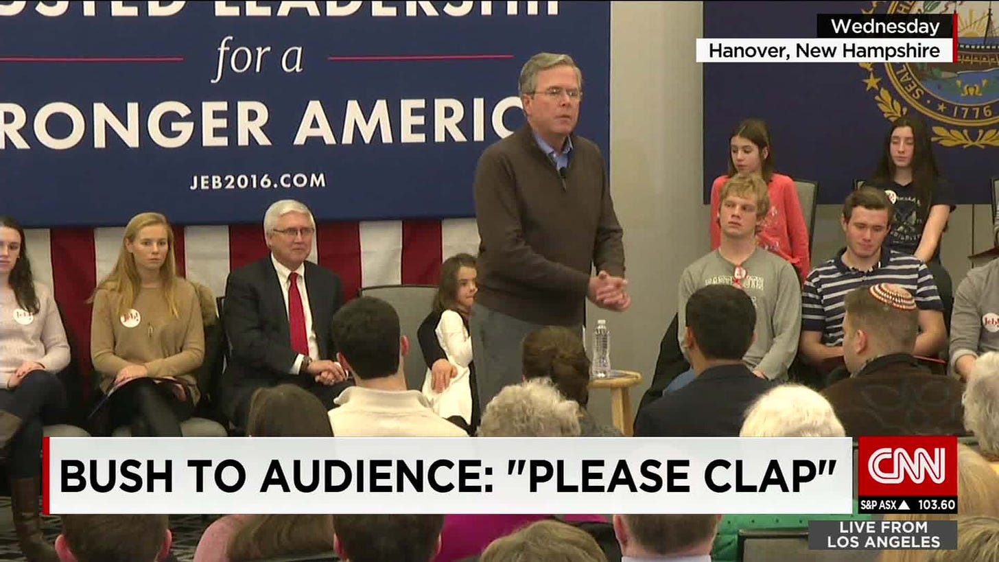 A CNN news screencap depicting Jeb Bush at a press conference with the caption "Bush to audience: 'Please clap'"