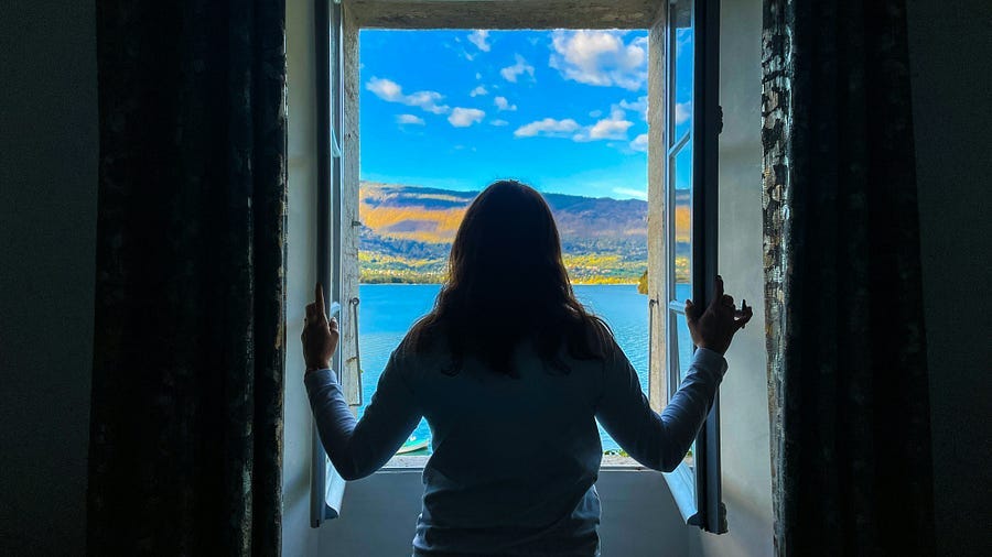 Woman looking through an open window. Woman looking through an open window.