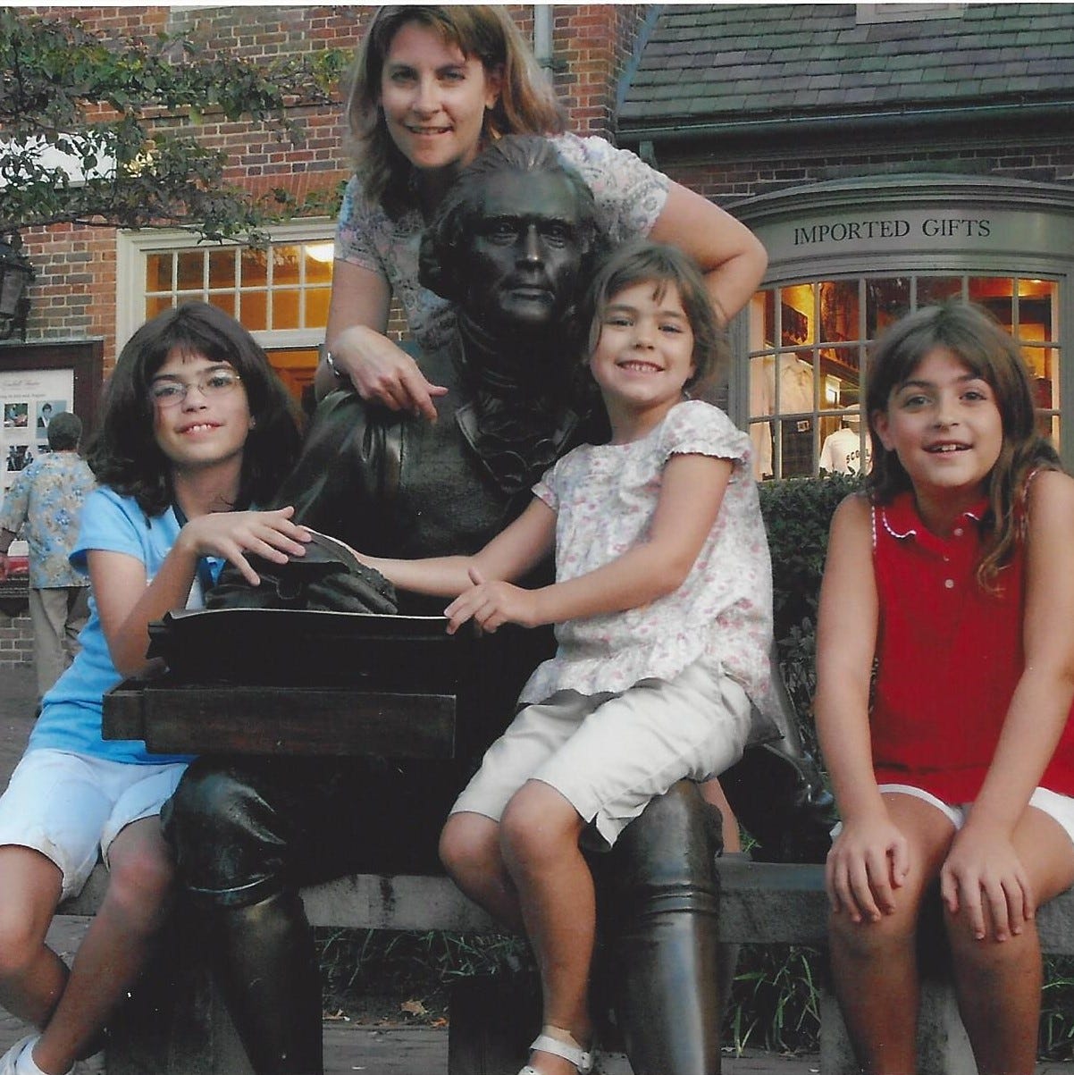 Family posed by a life-sized statue of Thomas Jefferson in Williamsburg, VA.