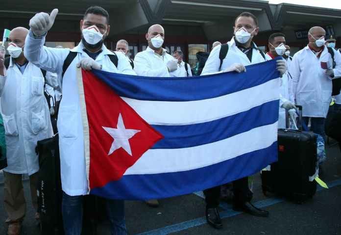 A group of people in white masks holding a flag

Description automatically generated with low confidence