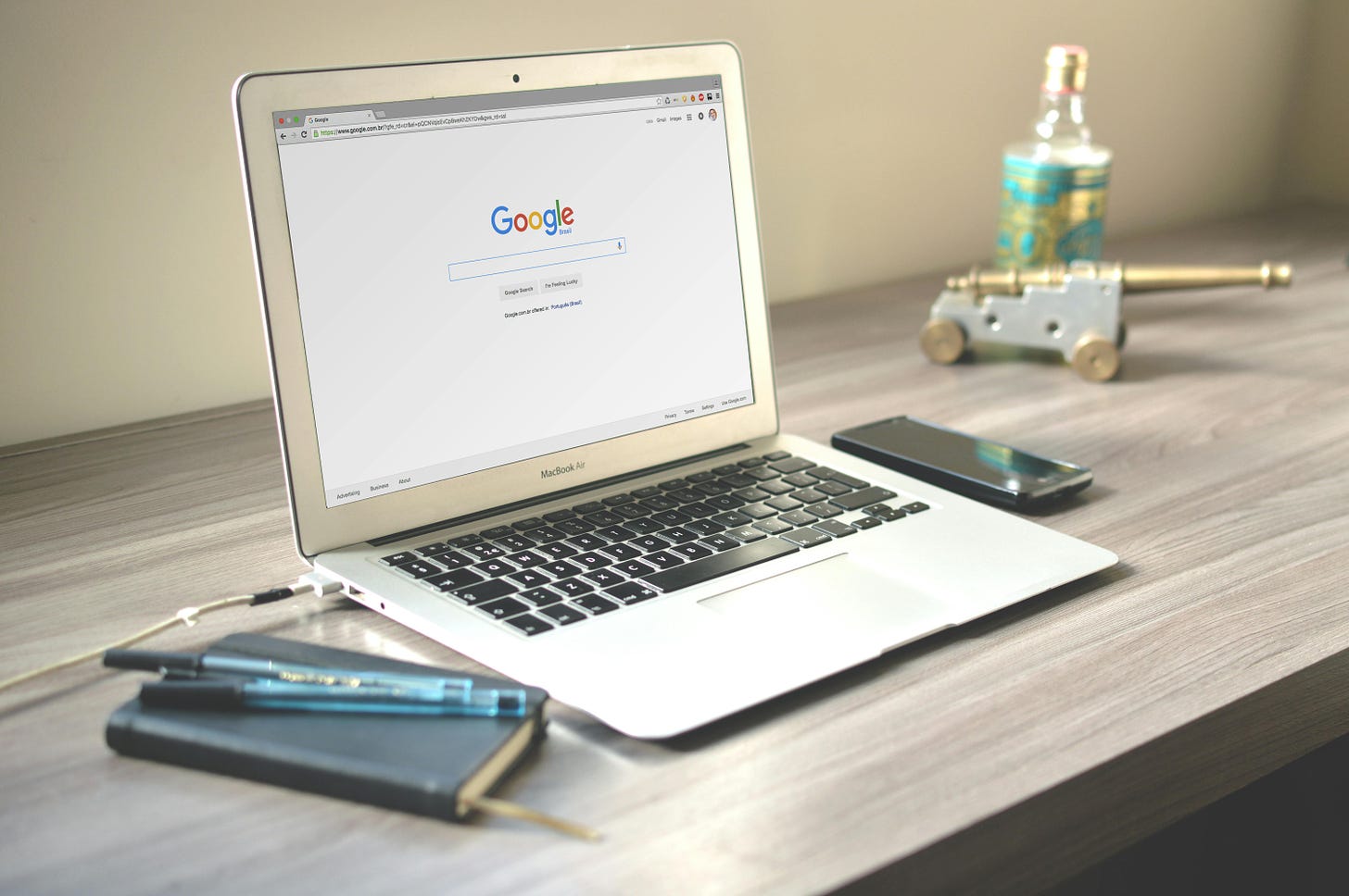 A mac laptop sits on a desk with Google open on it.