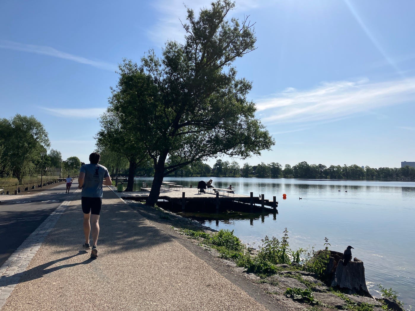 Running by the lake, two people fishing on a pier. Running by the lake, two people fishing on a pier.