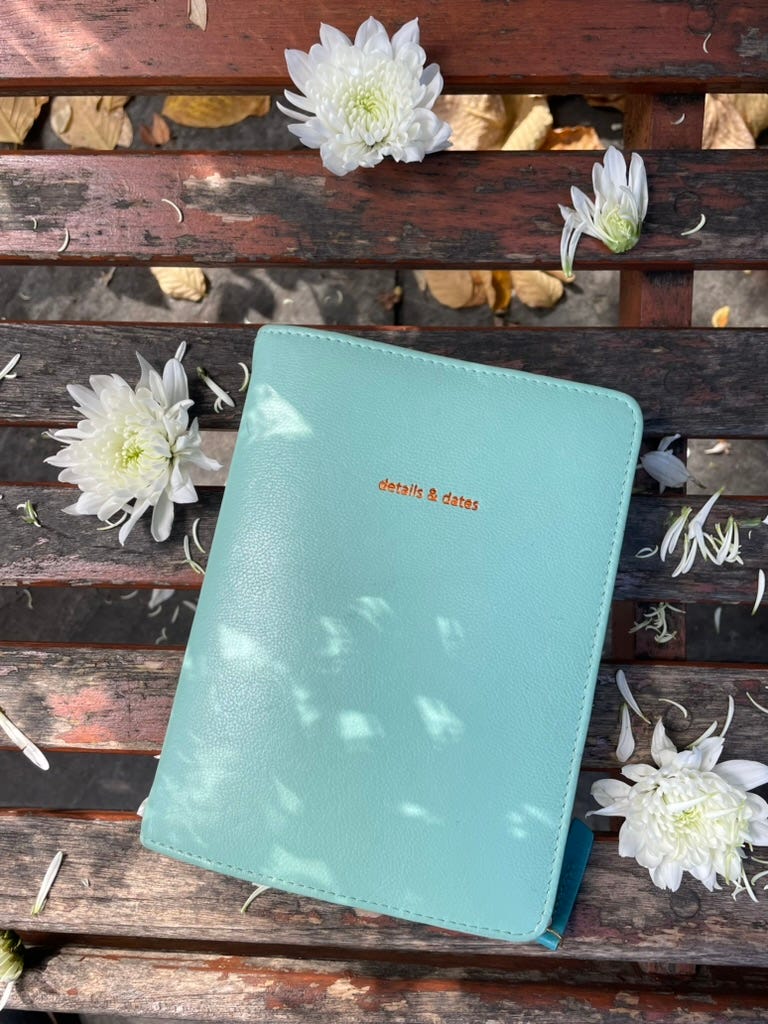 a journal on a park bench with scattered flowers