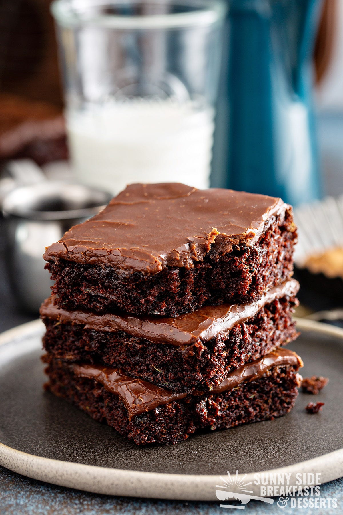 Three stacked zucchini brownies, one with a bite taken out.