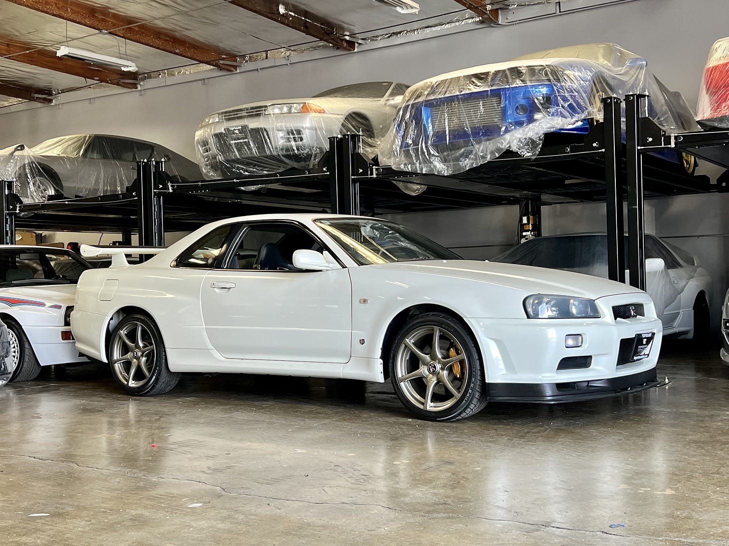 Side profile of a white R34 Skyline GT-R M-Spec Nür as reported in the new nonfiction book 'Cult of GT-R' by Ryan K. ZumMallen.