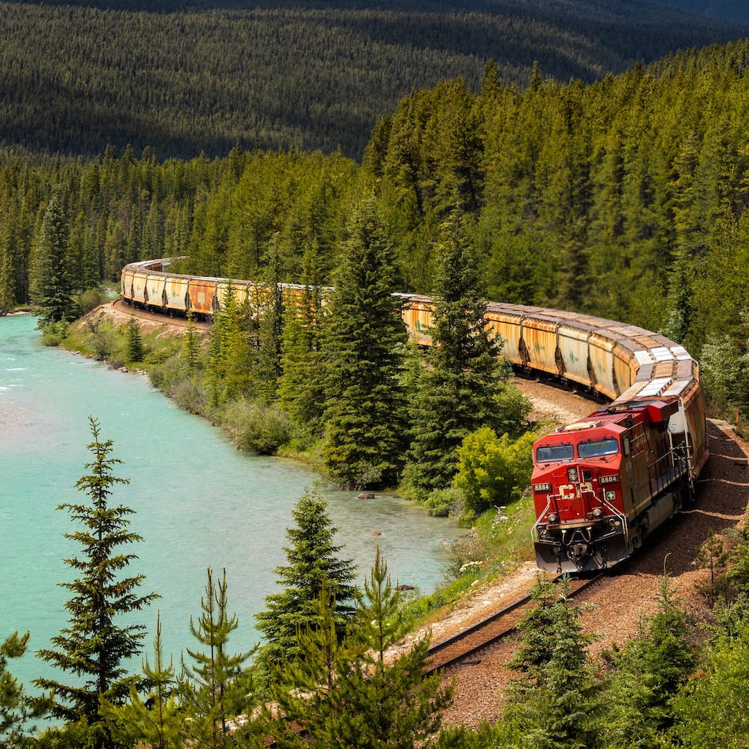 Long freight train winding through forested mountains