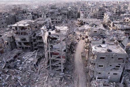 Palestinians walking through the destruction caused by the Israeli air and ground offensive, in Rafah, Gaza Strip, on 21 January 2025.