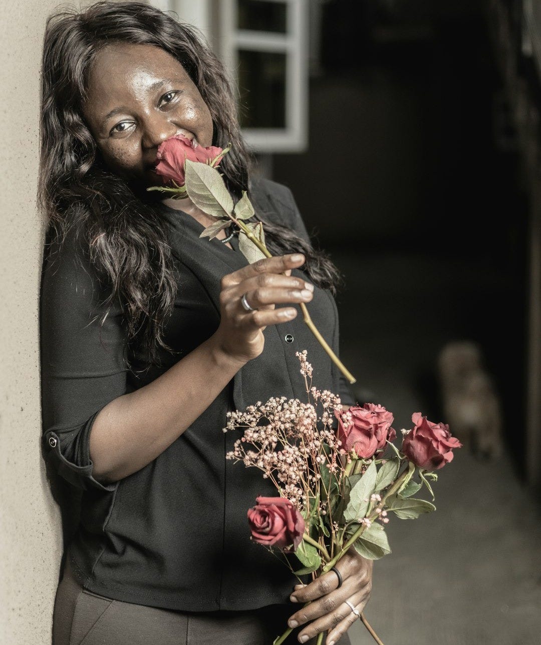 a woman holding a bunch of flowers in her hands