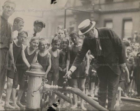 an old black and white photo of people standing around a fire hydrant