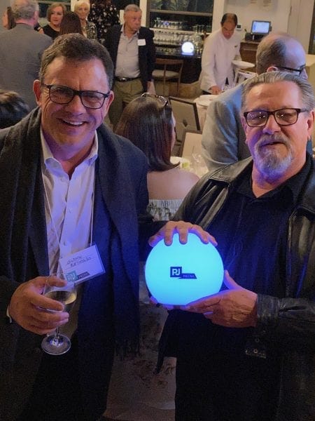 Two men holding a glowing ball

Description automatically generated