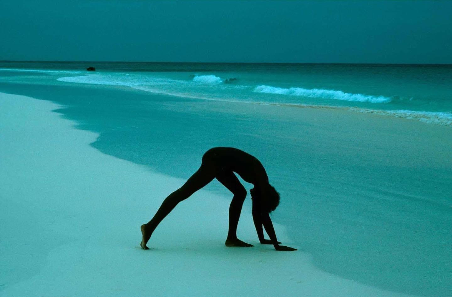 May be an image of 1 person, practising yoga, beach and ocean