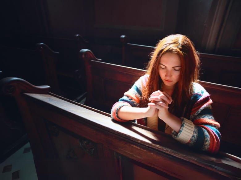 Single woman praying in Church