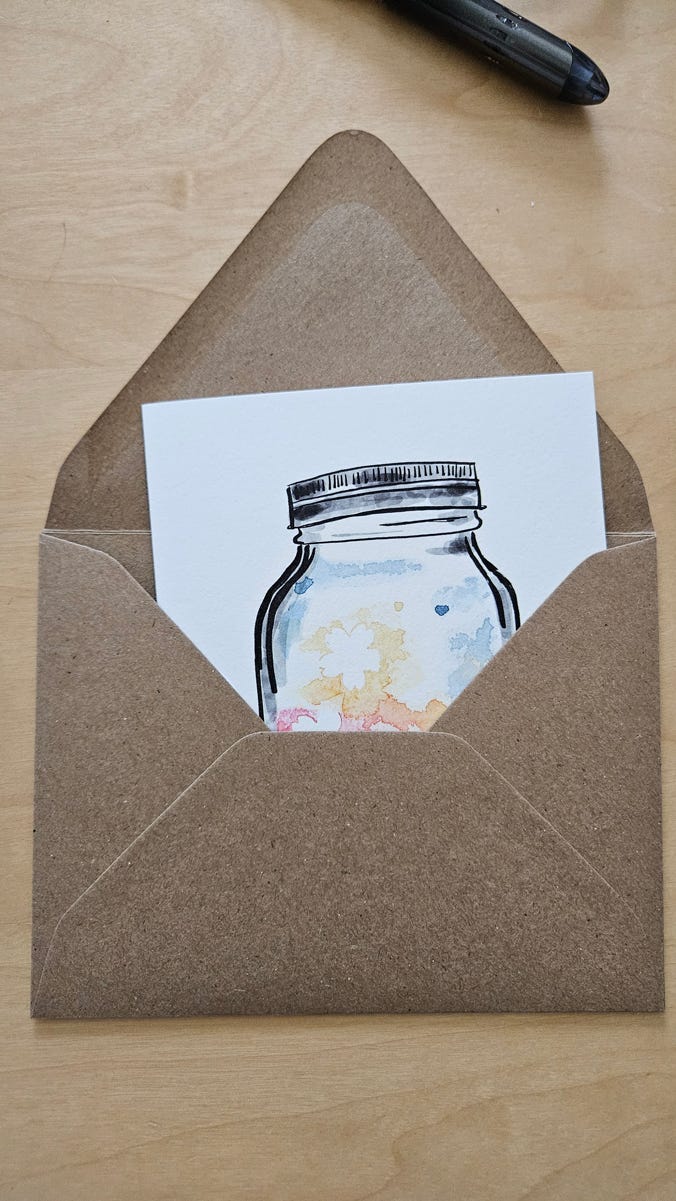 The back of a brown craft paper envelope. The open flap reveals a card with a drawing of a capped mason jar