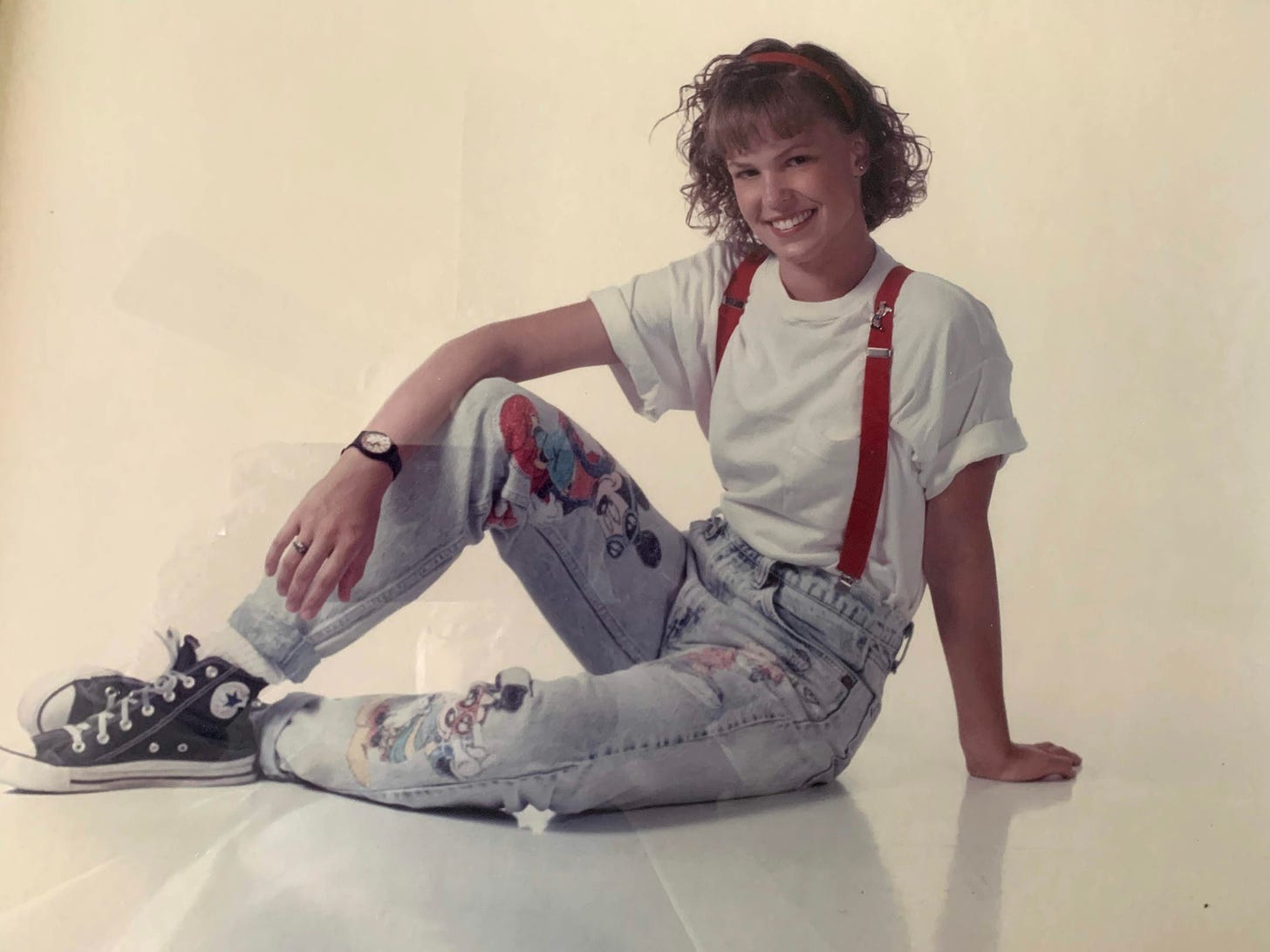 CB posing for her senior photo with appliqued Mickey Mouse images on her jeans