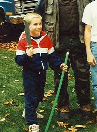 The author as a little boy, holding a rather large knife, standing next to a man in camouflage.