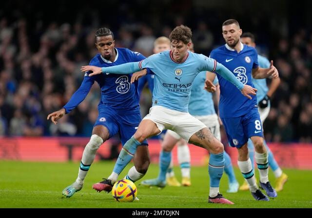 Manchester City's John Stones, centre, challenges for the ball with  Chelsea's Mateo Kovacic, right, and Carney Chukwuemeka, left, during the  English Premier League soccer match between Chelsea and Manchester City at  Stamford