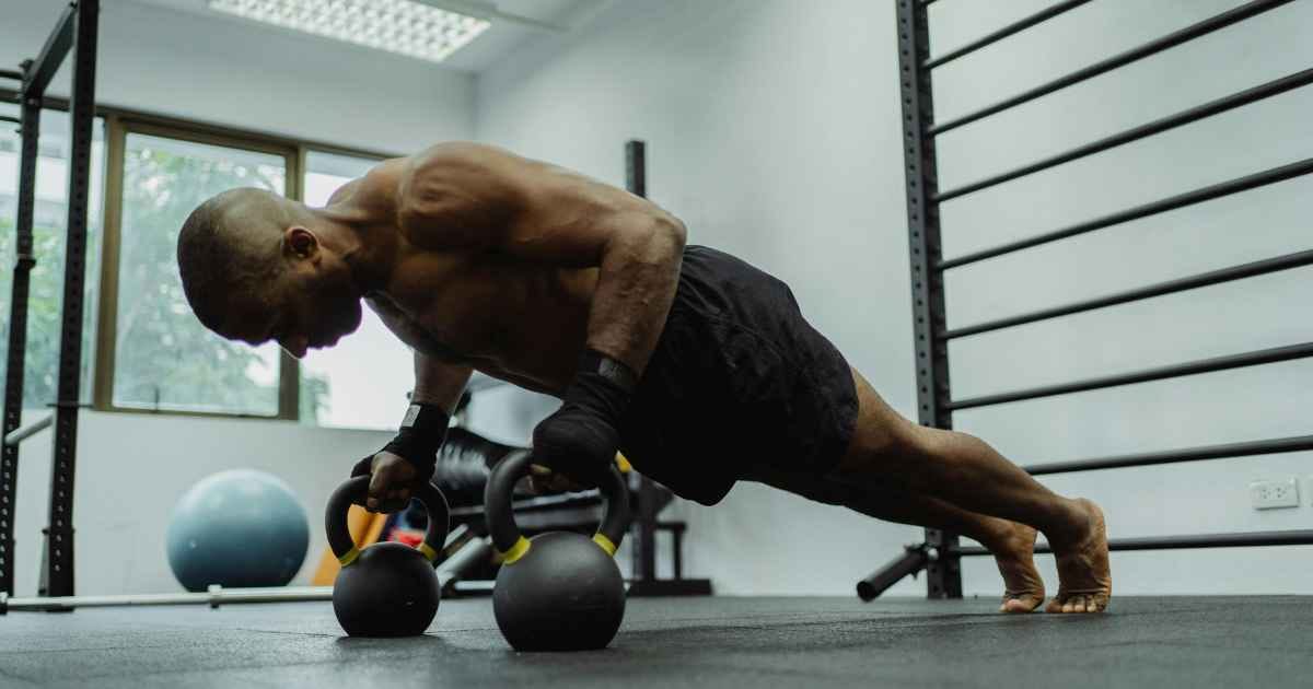 A man doing push-ups with kettlebells