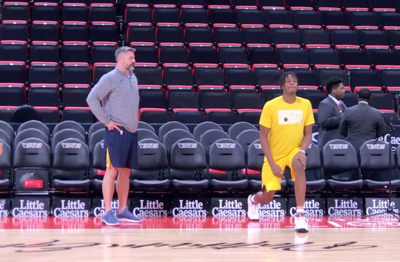 Pacers sports performance coach Shawn Windle looks over Myles Turner going through pregame stretches.