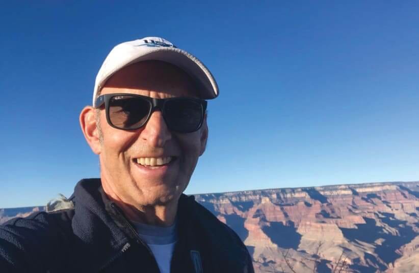 Howard Blas stands against the skyline of the desert in Israel with a blue sky behind him