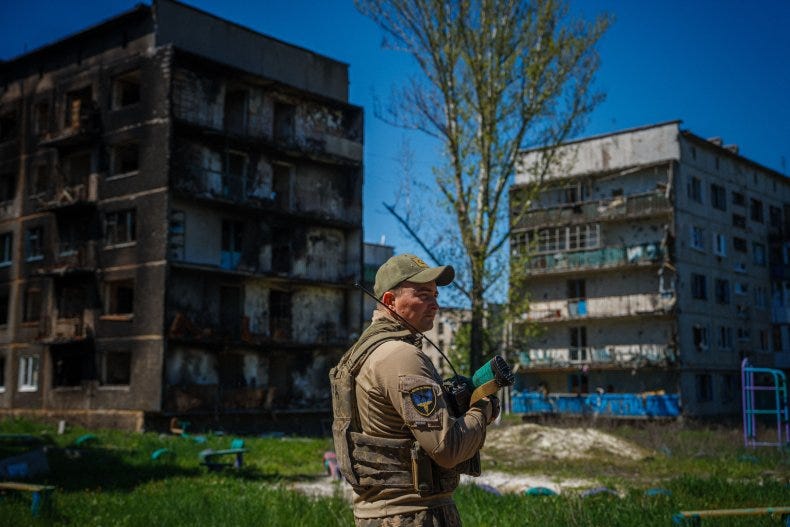Ukraine border guard with damaged Bakhmut buildings