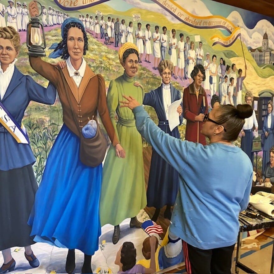 Artist Phyllis Garibay Coon Pease in front of Rebel Women mural