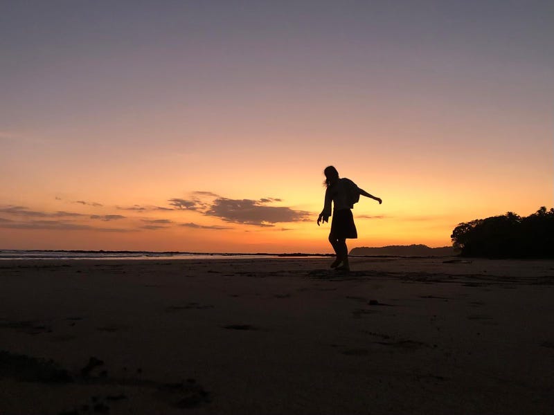 Silhouette dancing on the beach at dusk.