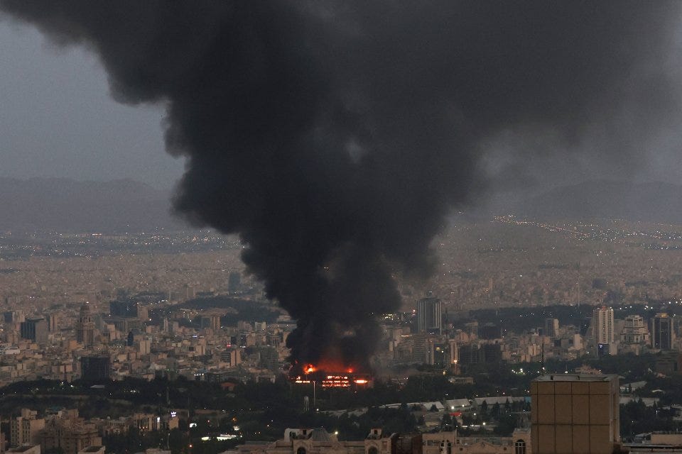 Large fire in a city, with thick black smoke billowing into the air.