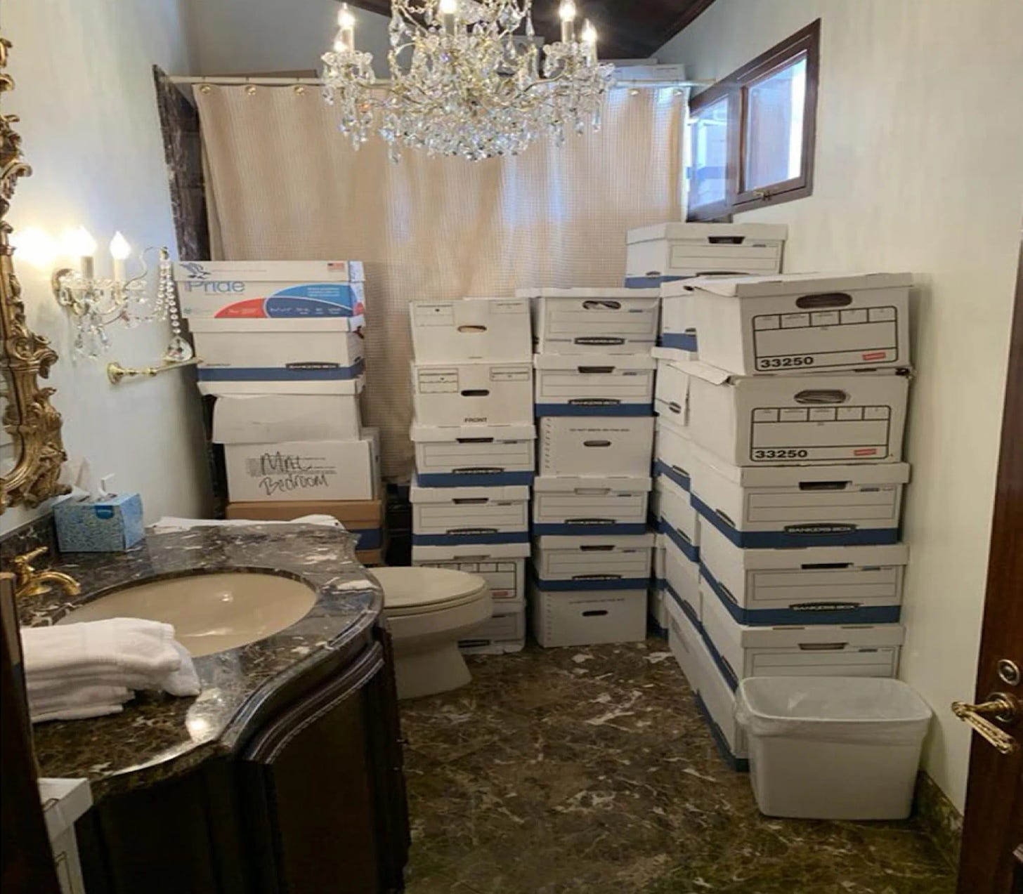 Several boxes of presumably classified documents in what looks like a hotel ballroom's bathroom.
