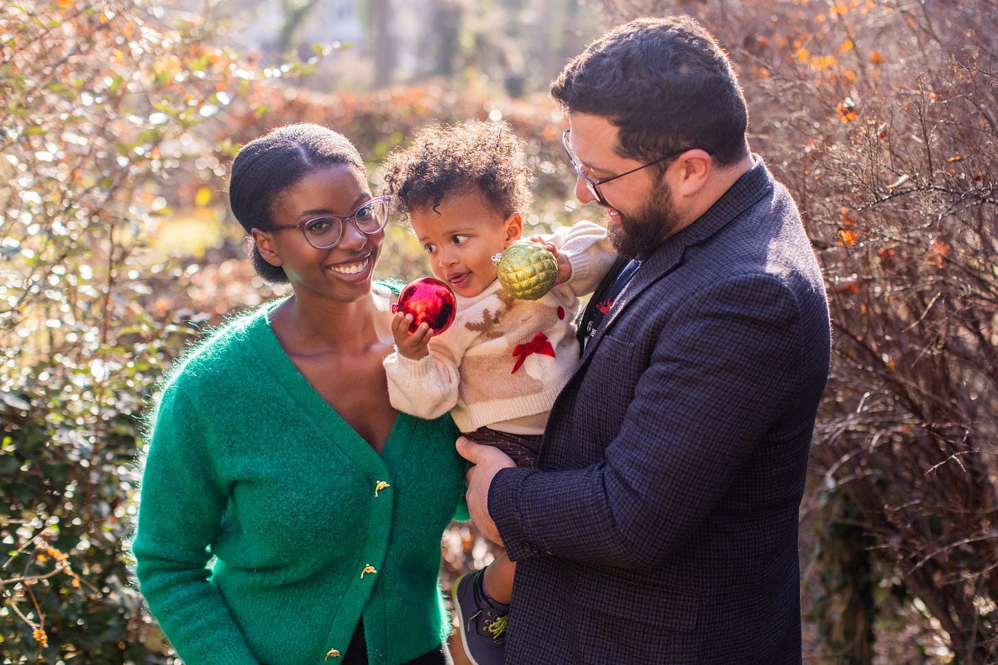 A family smiles in their backyard for holiday family photos.