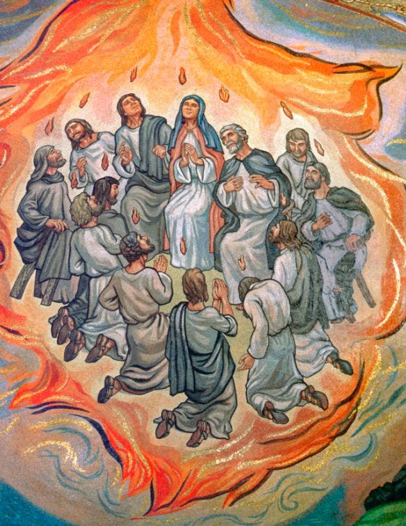 A group of people in grey robes are gathered together. Flames are shown over their heads and they are enshrouded in a larger flame.