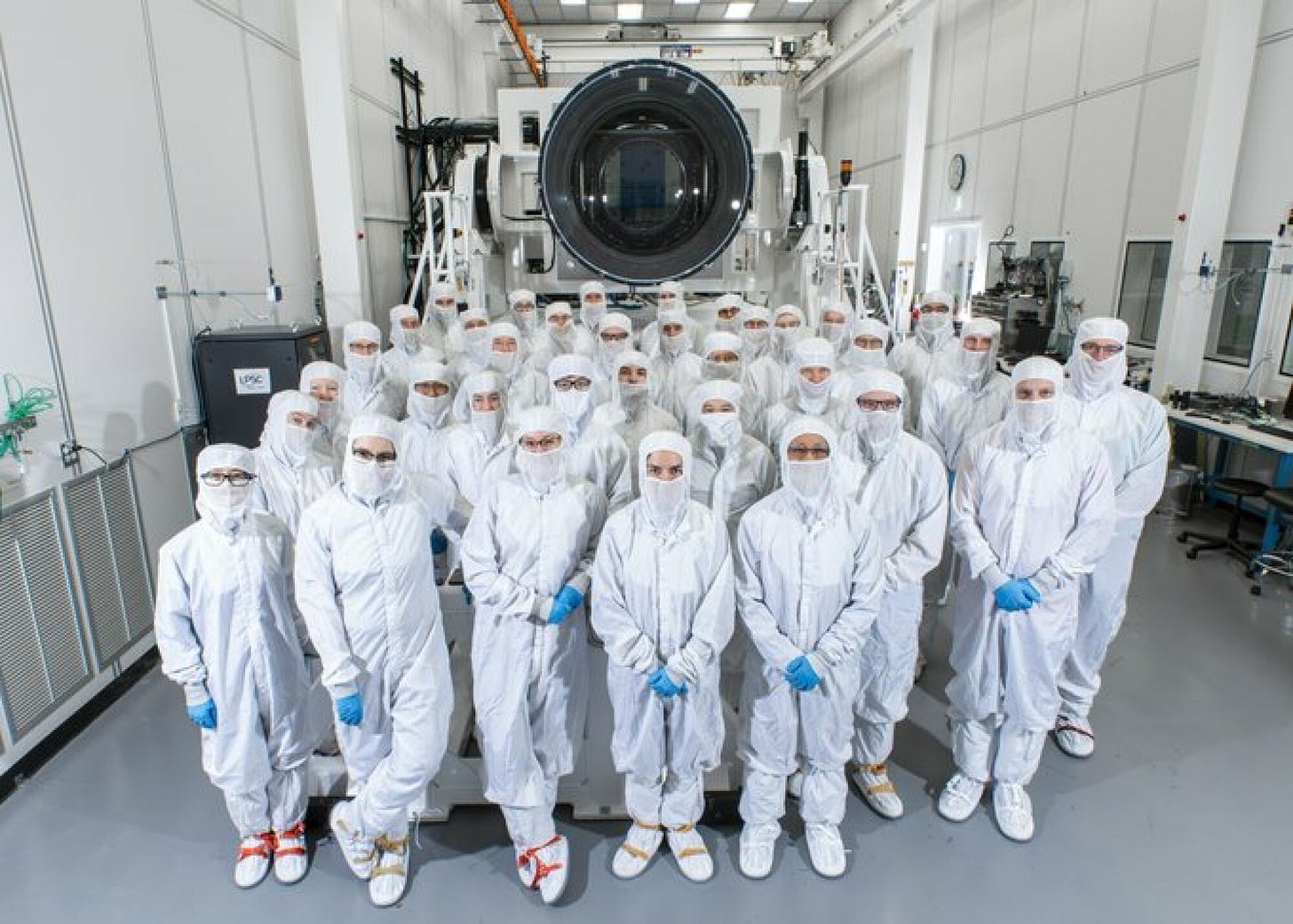 The SLAC team building the LSST camera pose in front of the instrument in a clean room in Menlo Park, California.