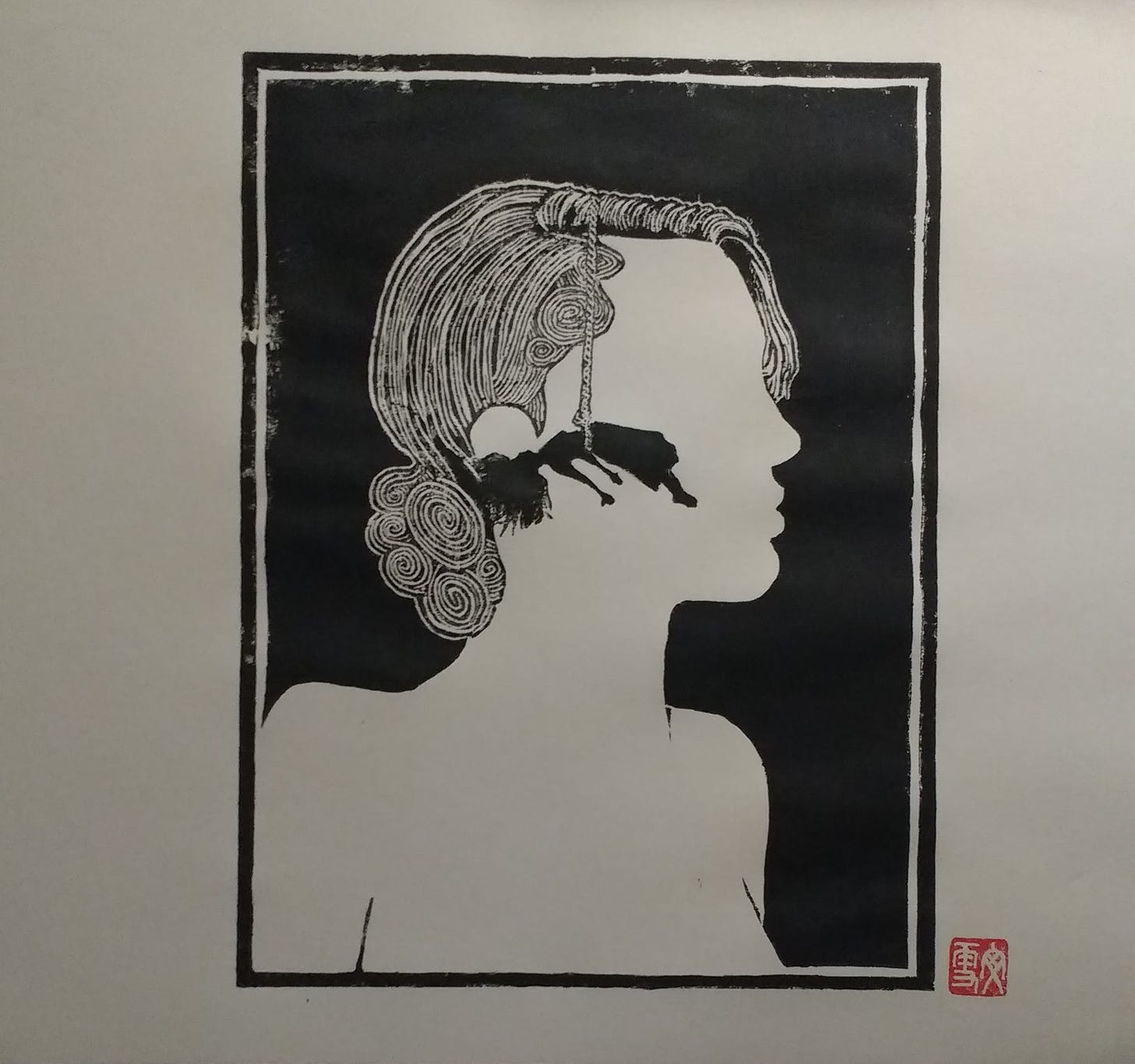 A linocut print of a woman's face. Inside her head is a woman hanging by a rope (or hair) from her waist.