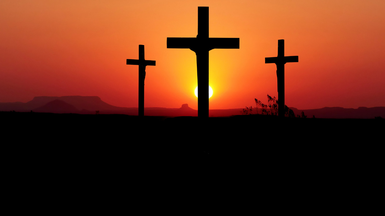 Three cross in the orange setting sun.