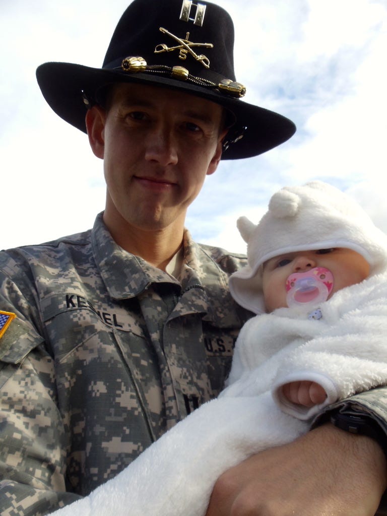 A soldier holding a baby

Description automatically generated