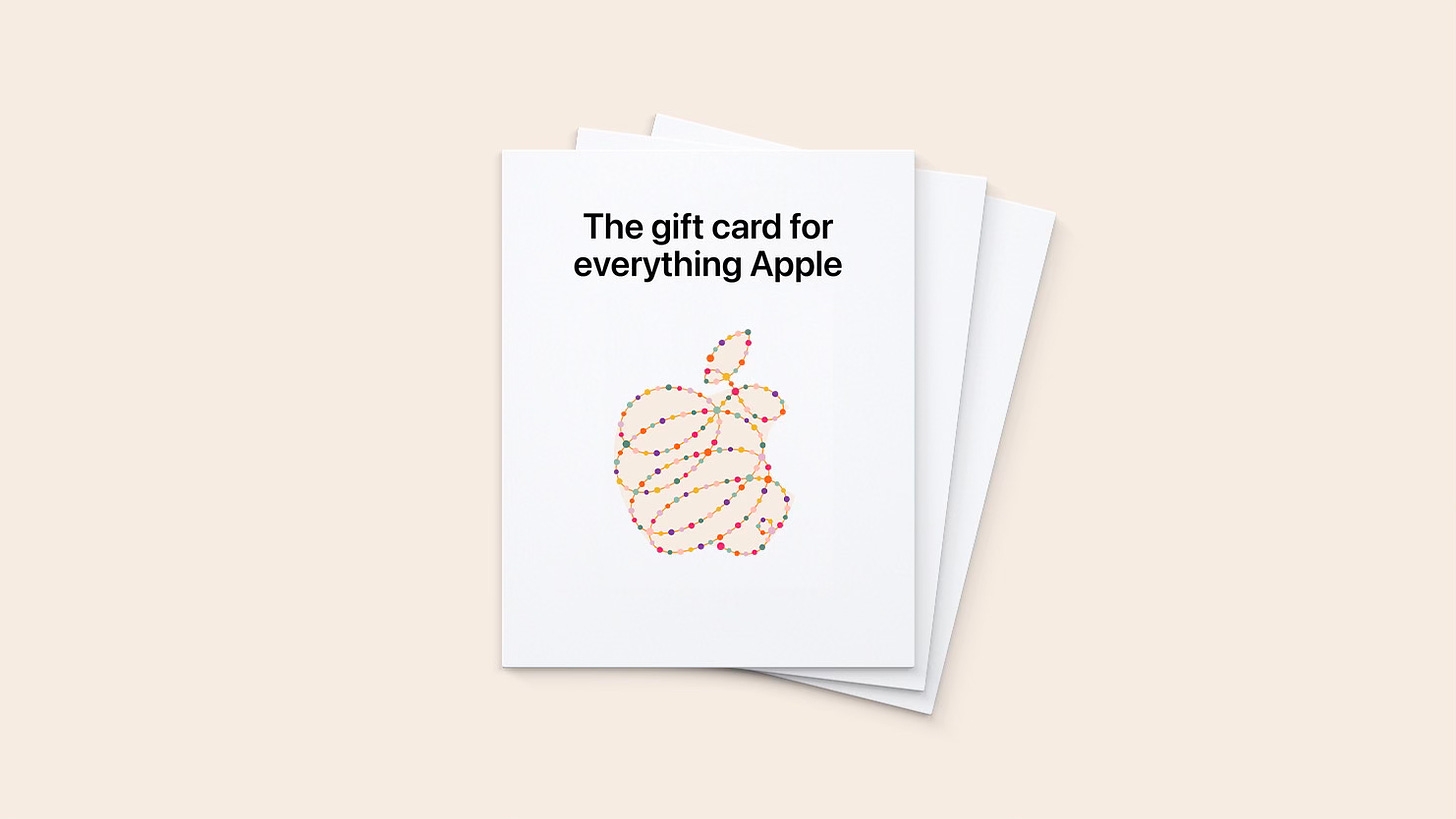 Three holiday 2023 Apple Gift Cards stacked on top of each other. The Apple logo resembles a string of festive lights.