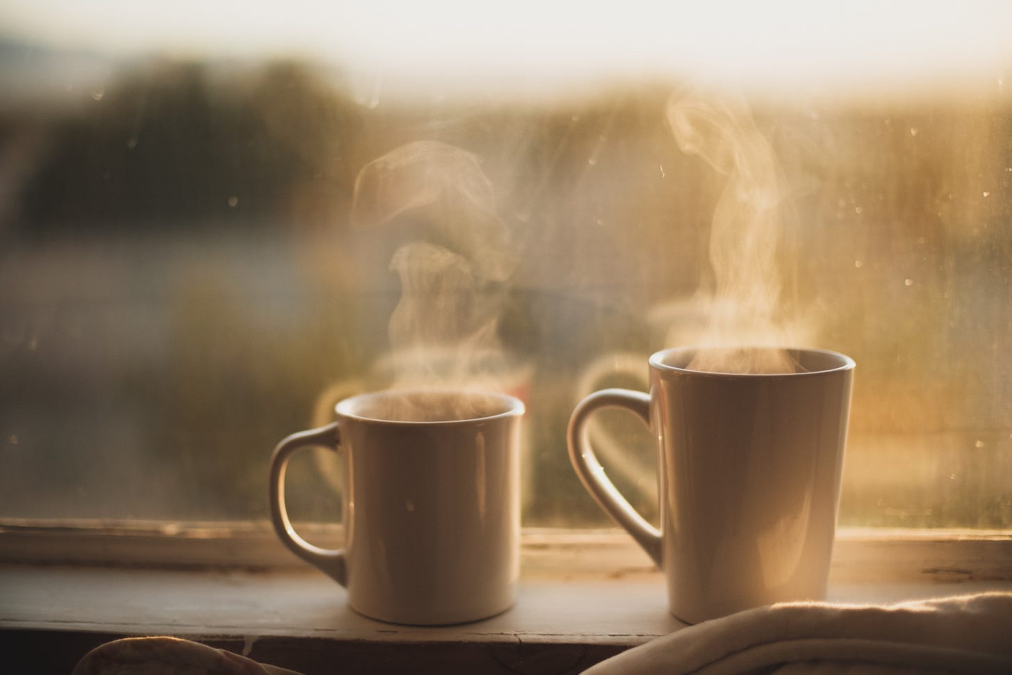 Photo of two steaming coffee cups by John Gibbons.