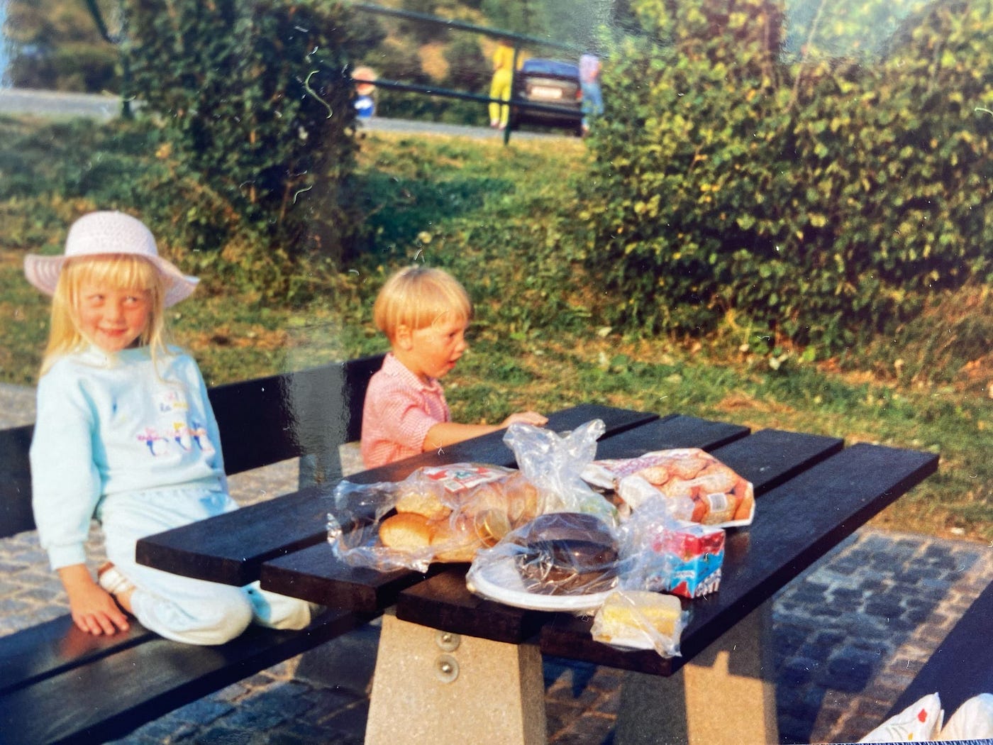 Image of author at six and her brother at three eating a picnic in 1990