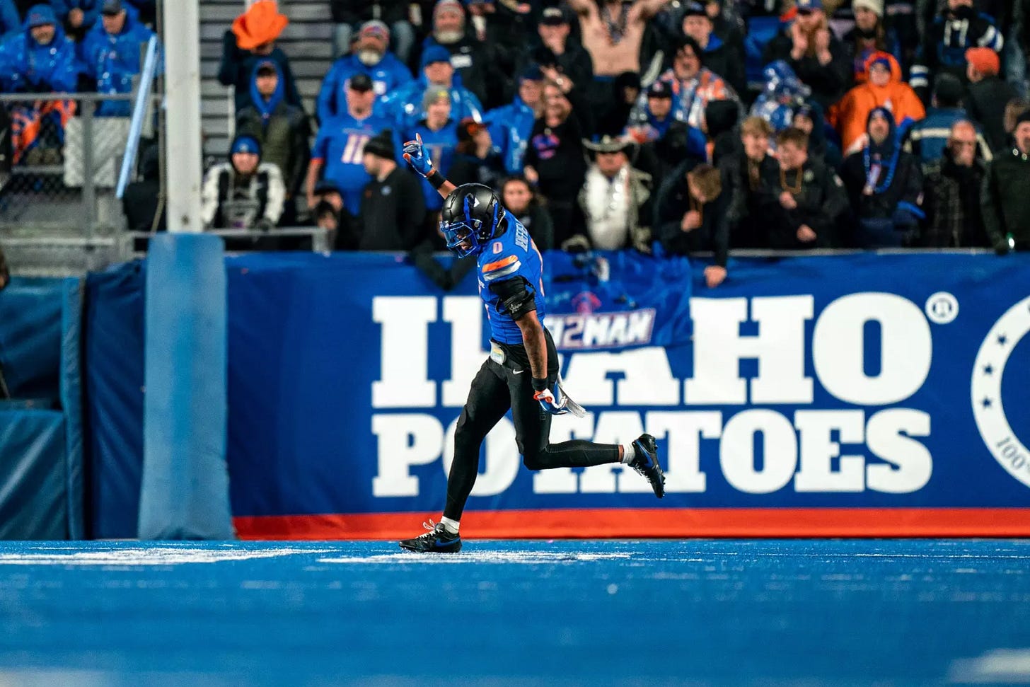 Ty Benefield runs with his right arm up and index finger pointed to the sky during a Boise State Broncos football game.