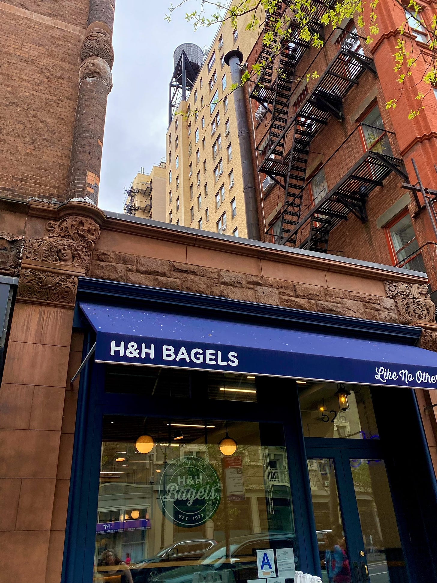 A water tower visible on the roof next to an H & H Bagels.